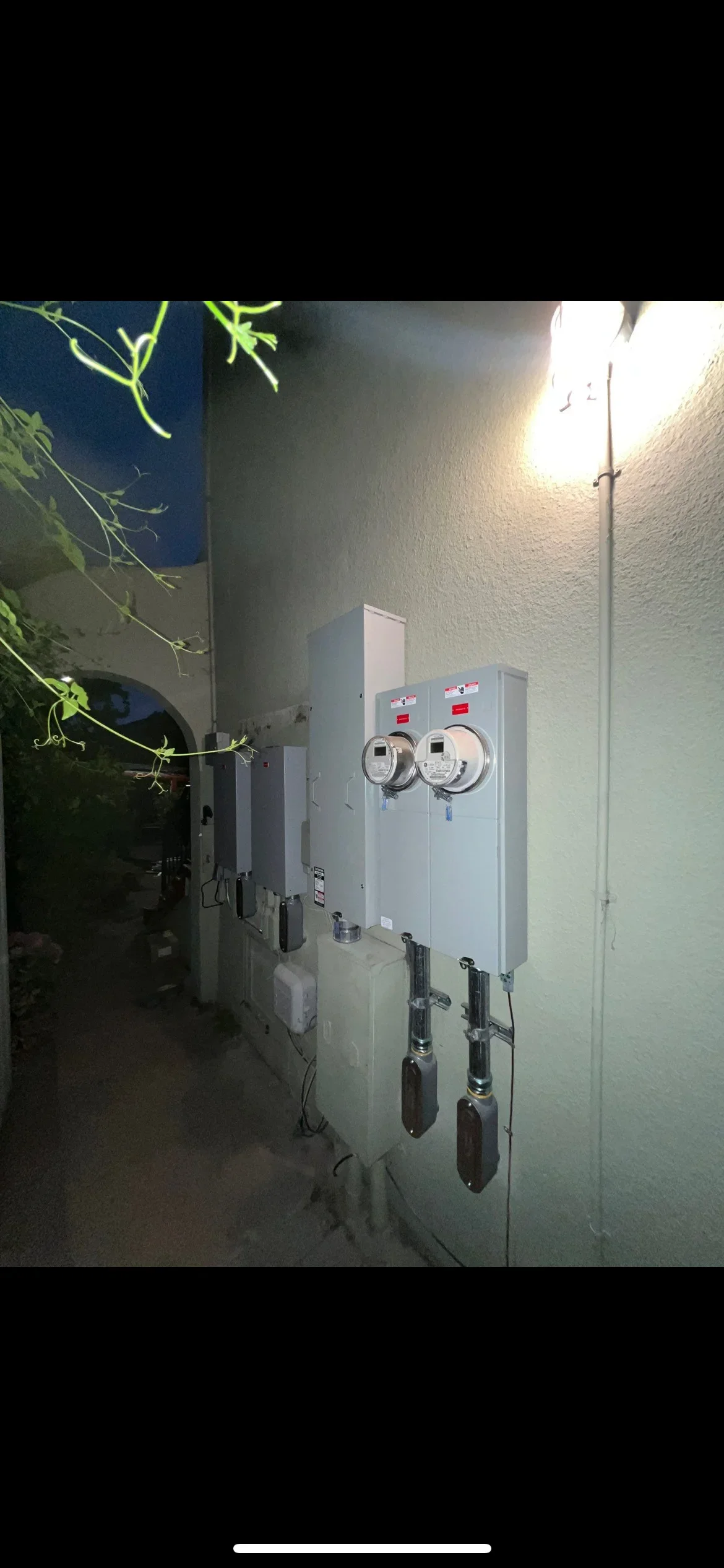 Dual 200 amp meter boxes with breakers and conduit on stucco exterior wall